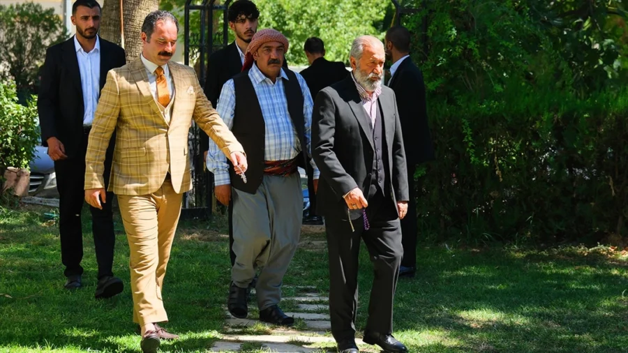 Three members of the Halef cast stand outdoors in a scene from the series.