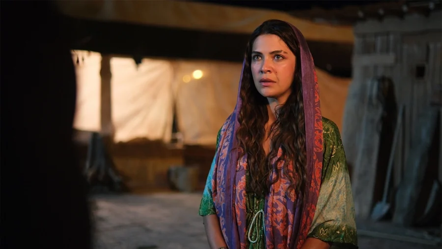 A woman sits in a softly lit room in a scene from Halef: Köklerin Çağrısı.