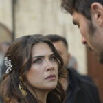 A woman and a man face each other in an interior scene from Halef Episode 18.